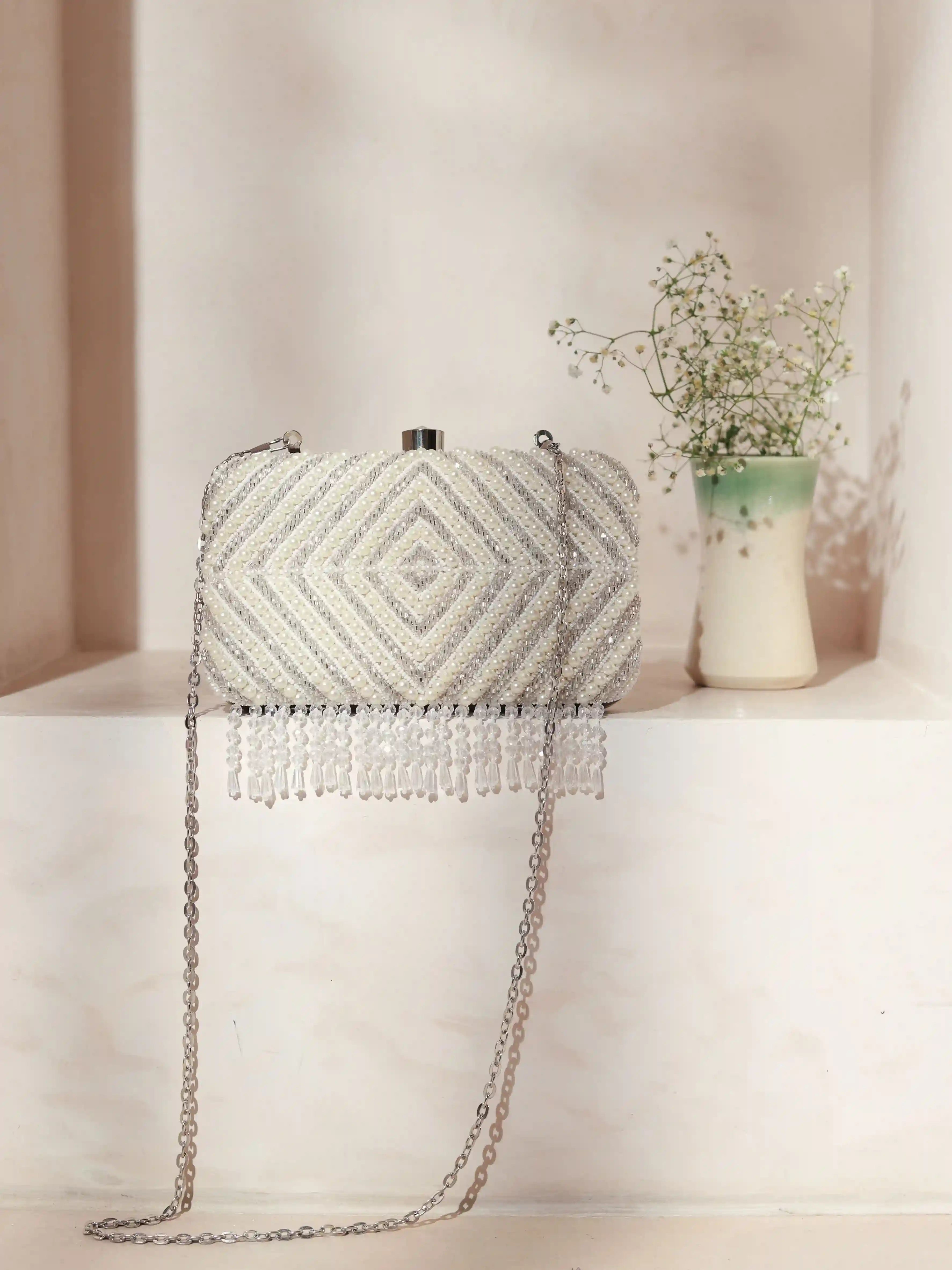 Silver embroidered clutch bag with pearly accents, handcrafted by The Tan Clan, featuring intricate hand embroidery and a sleek design.