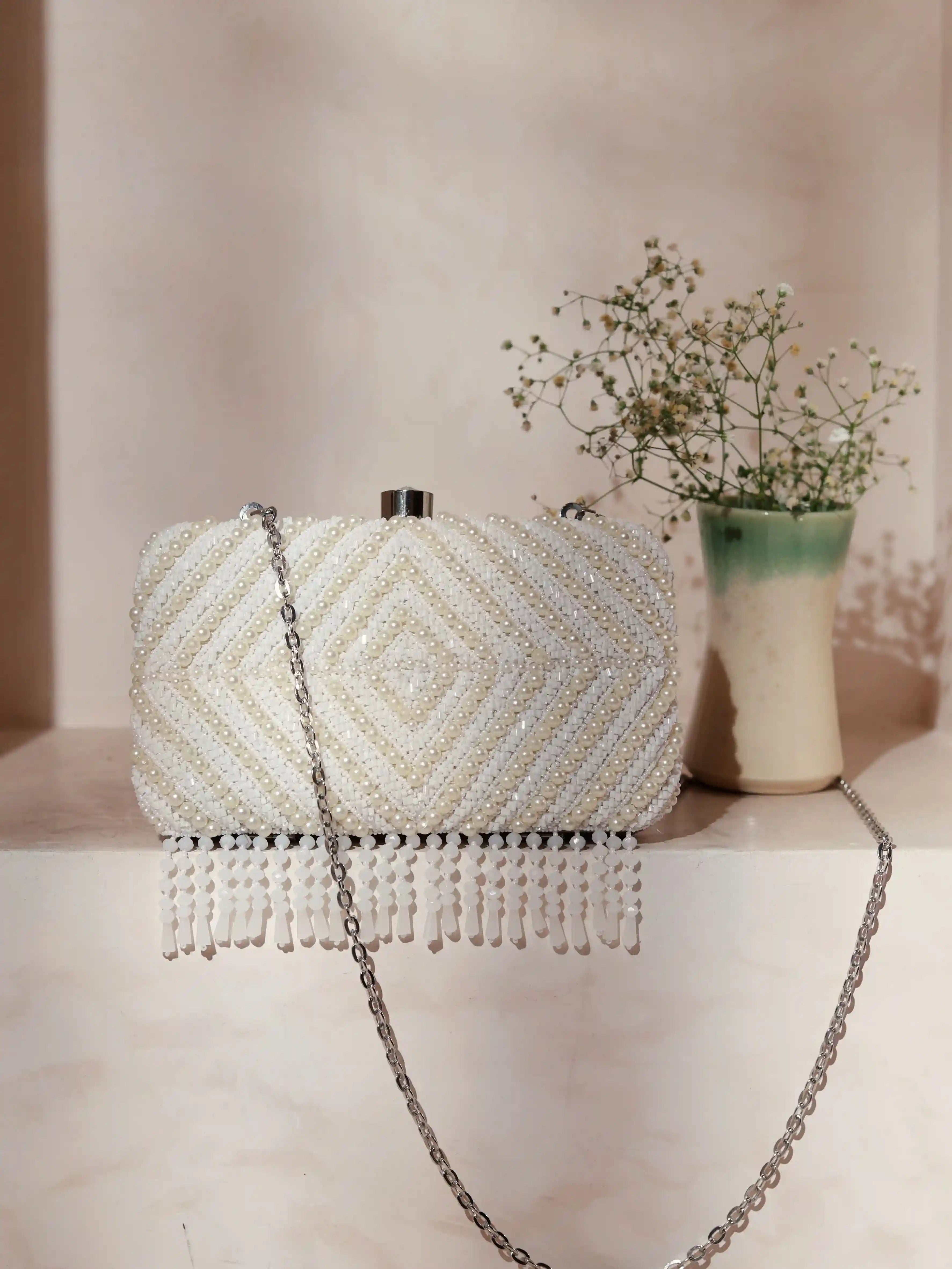 Pearly White hand-embroidered clutch bag with intricate floral designs by The Tan Clan, featuring a sleek, elegant accessory for special occasions.