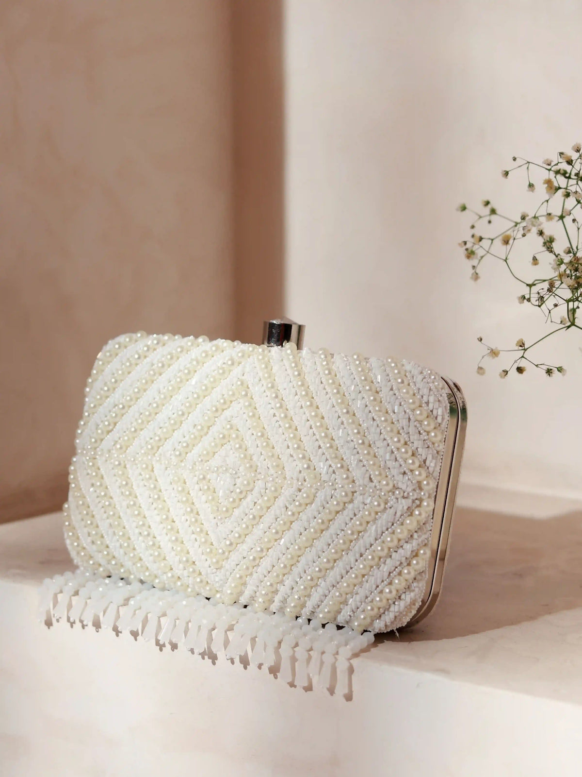 Pearly white hand-embroidered clutch bag with intricate detailing, crafted by The Tan Clan for elegant evening occasions.