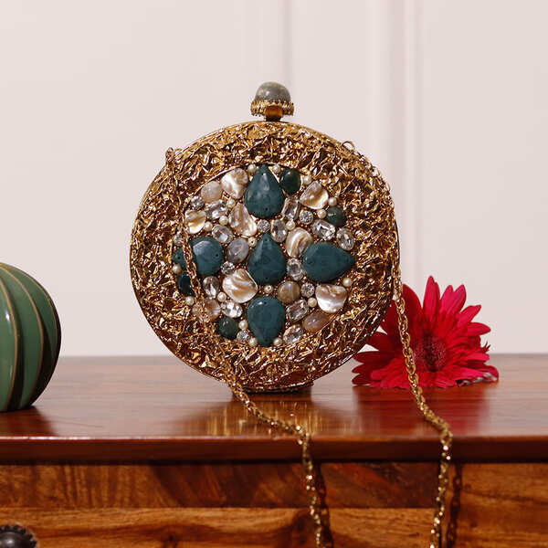Brass clutch bag by The Tan Clan with intricate embellishments and decorative details, showcasing a stylish and elegant accessory.