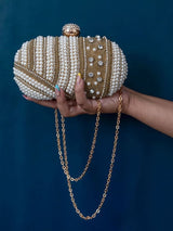 Rabia Golden Hand Embroidered Pearl Clutch with intricate gold embroidery and pearl accents, held in a hand against a neutral background.