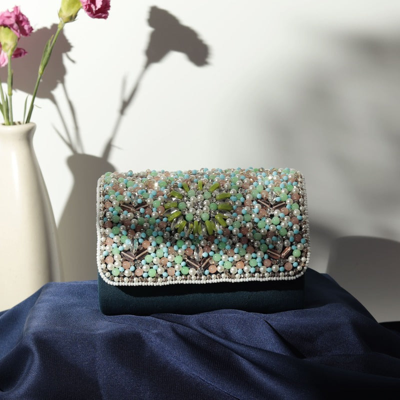 Rainbow embellished flap-over clutch bag by The Tan Clan with colorful decorative details and a sleek design.