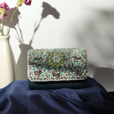 Rainbow embellished flap-over clutch bag by The Tan Clan with colorful decorative details and a sleek design.