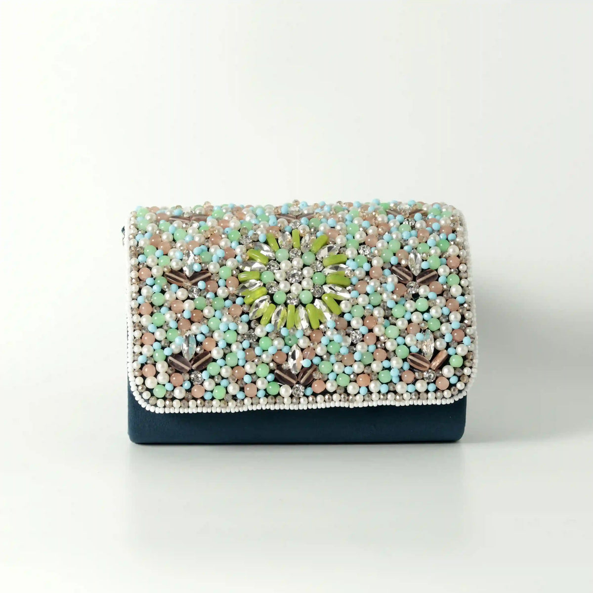 Rainbow embellished flap-over clutch bag by The Tan Clan with colorful decorative details and a sleek design.