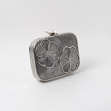 Reema silver brass wirework clutch with intricate design, crafted by The Tan Clan, showcasing detailed metal craftsmanship.
