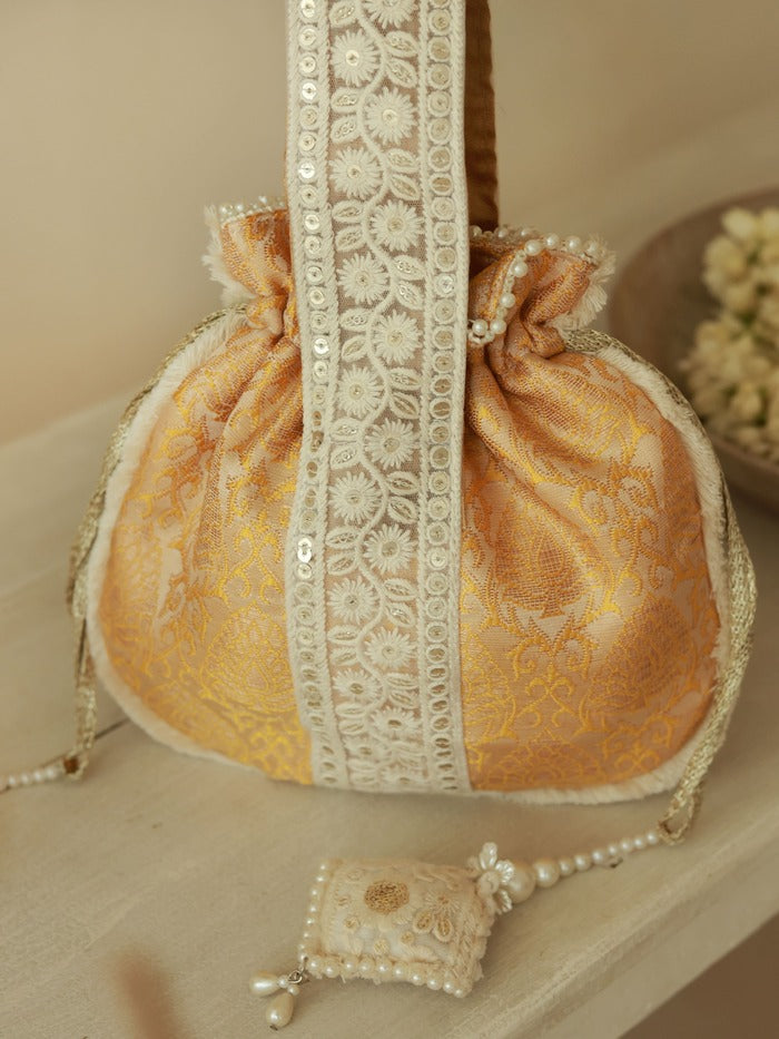 Yellow Ruhi Potli bag with handle from The Tan Clan, featuring intricate embroidery and traditional Indian design.