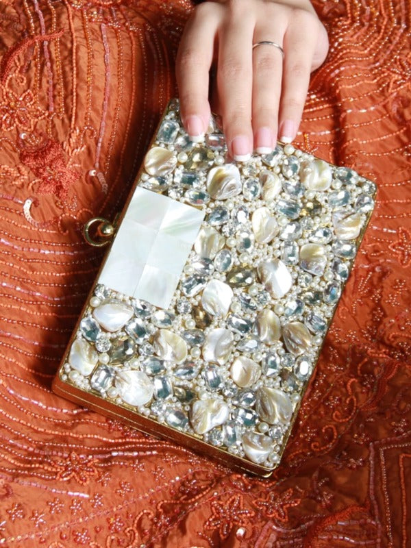Elegant brass clutch with intricate embellishments by The Tan Clan, showcasing detailed craftsmanship and stylish design.