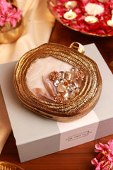 Elegant Sana embellished mother of pearl clutch by The Tan Clan with intricate design and shimmering surface.