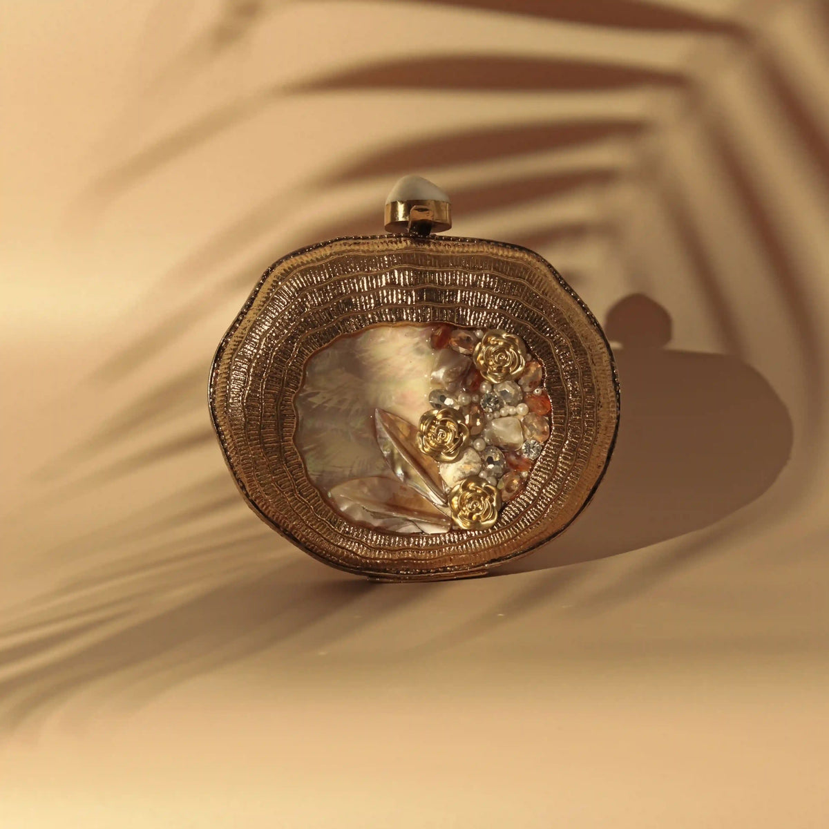 Elegant Sana embellished mother of pearl clutch by The Tan Clan, featuring intricate design and polished pearl accents.
