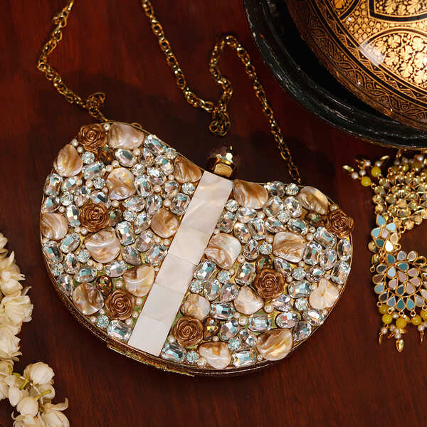 Golden brass clutch with intricate embellishments from The Tan Clan, featuring a stylish and elegant design.