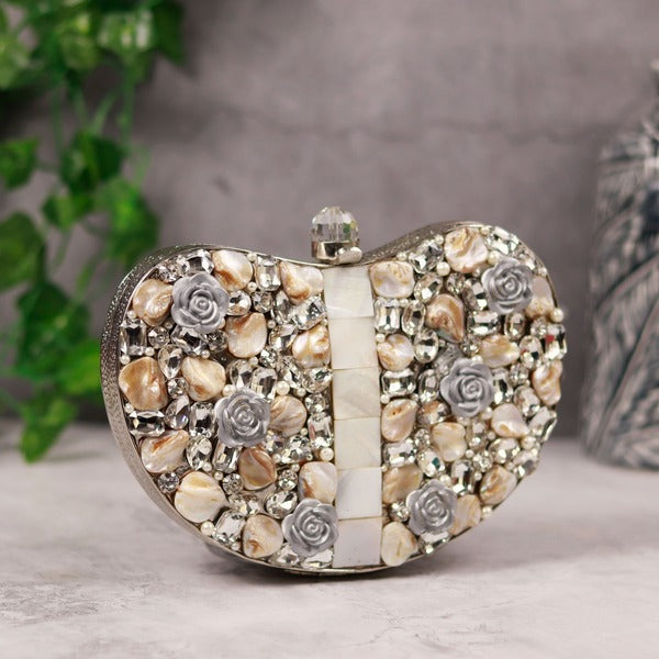 Silver brass clutch handbag with intricate embellishments by The Tan Clan, featuring detailed craftsmanship and elegant design.