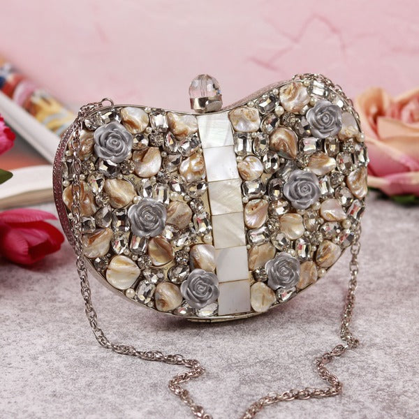 Silver brass clutch bag with intricate embellishments, featuring elegant design and a metallic finish, by The Tan Clan.