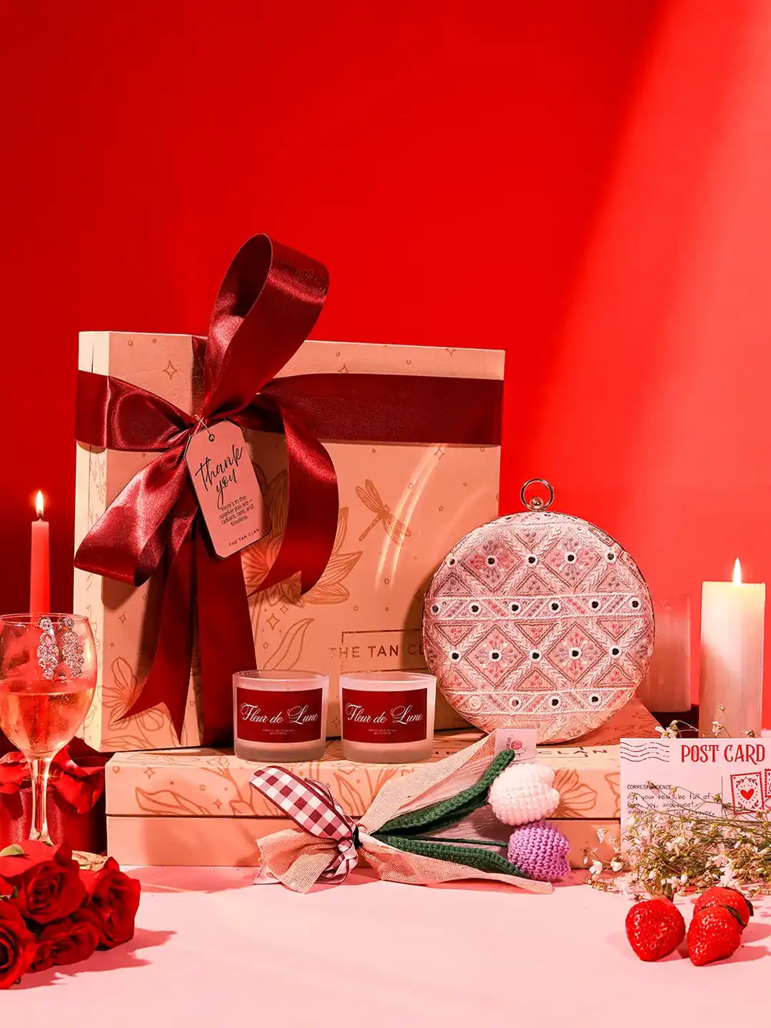 Soul-Care gift set featuring an Ariba clutch, candle, and flower arrangement from THE TAN CLAN, displayed together on a neutral background.