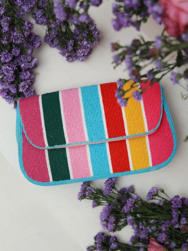 Multicolor stripe baguette bag with handle by The Tan Clan, showcasing vibrant patterns and a sleek, compact design.