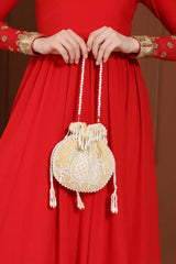 Beige Sukoon hand-embroidered potli bag with pearl handle by The Tan Clan, showcasing intricate embroidery and elegant design.