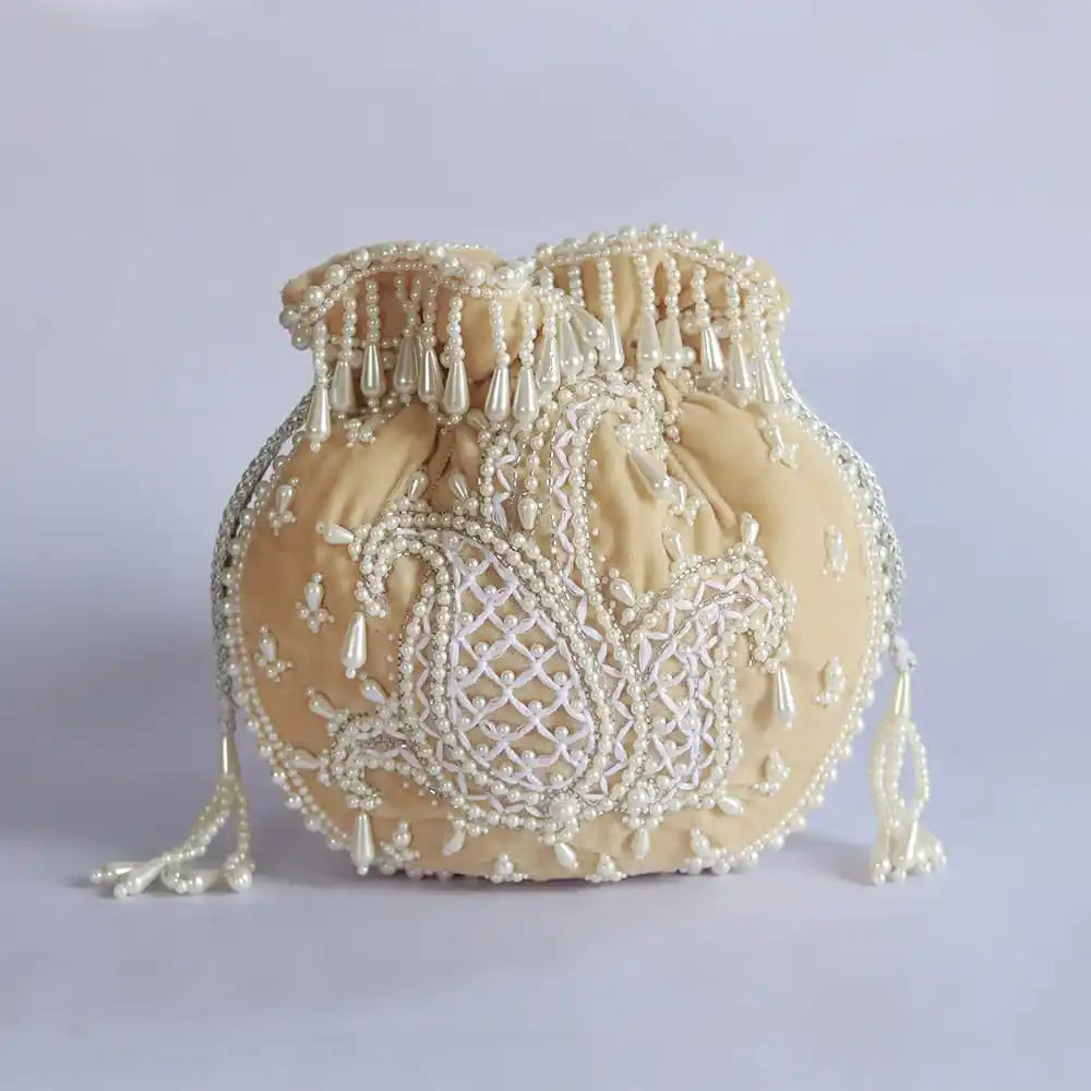 Beige Sukoon hand-embroidered potli bag with pearl handle from The Tan Clan, featuring intricate embroidery and elegant design.