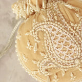 Beige Sukoon hand-embroidered potli bag with pearl handle from The Tan Clan, featuring intricate embroidery and elegant design.