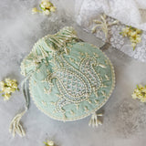 Blue Sukoon hand-embroidered potli bag with pearl handle by The Tan Clan, featuring intricate embroidery and elegant design.