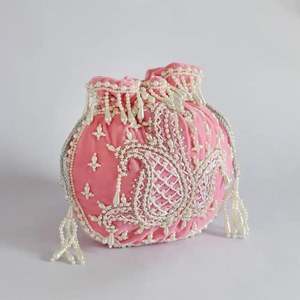 Pink Sukoon hand-embroidered potli bag with pearl handle by The Tan Clan, featuring intricate embroidery and elegant design.