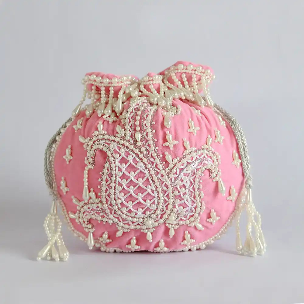 Pink Sukoon hand-embroidered potli bag with pearl handle, featuring intricate embroidery from The Tan Clan.
