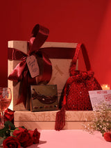 Set of 2 Rosa Potli sweet treat hampers from THE TAN CLAN with chocolates, featuring vibrant pink fabric and decorative design.