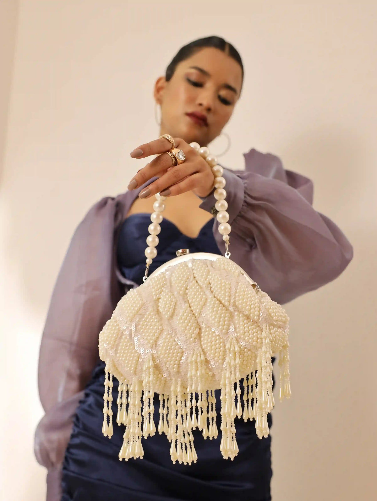 Tara Pearl Tasselled Batua bag with detachable handle by The Tan Clan, featuring pearl embellishments and tassel accents.
