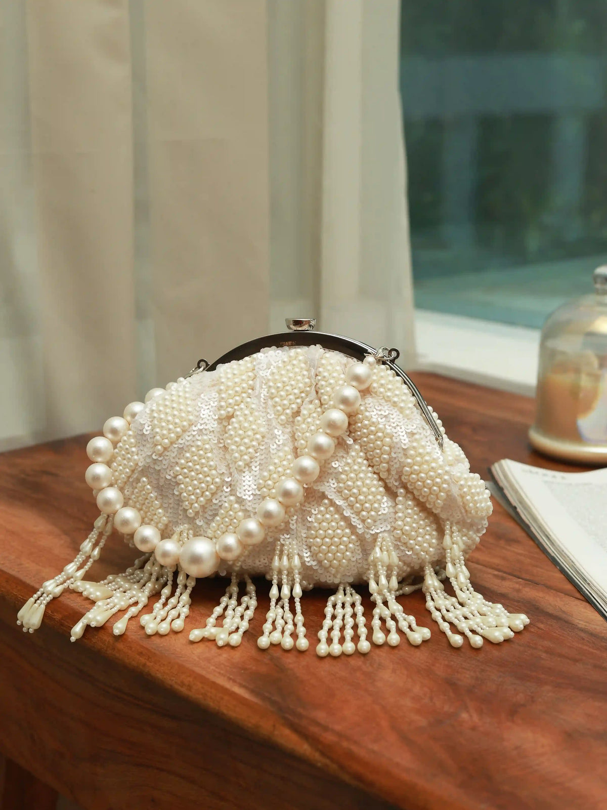 Tara Pearl Tasselled Batua bag with detachable handle by The Tan Clan, featuring pearl embellishments and intricate tassel details.