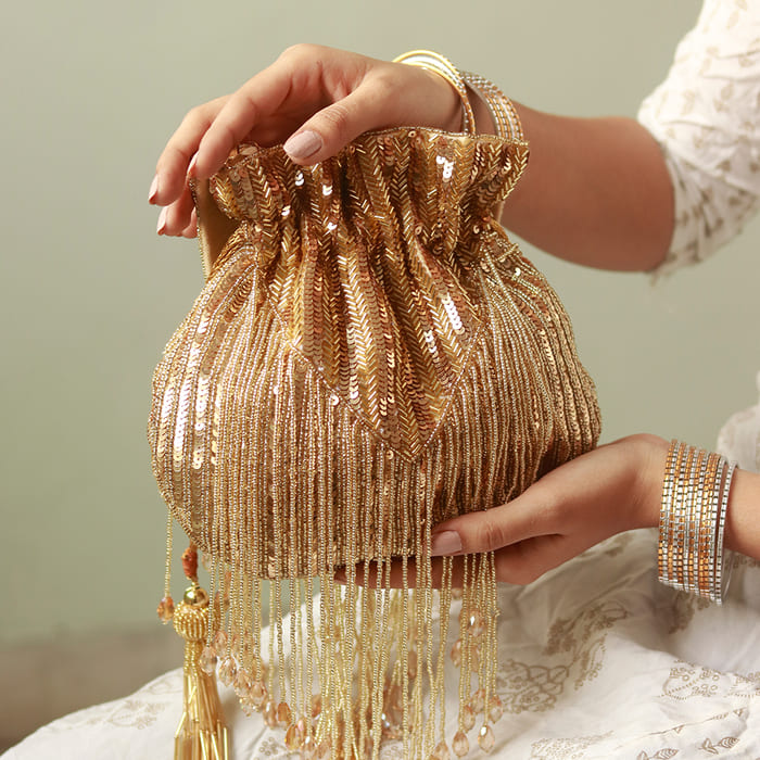 Gold Twinkle Heavy Tassles Potli bag with handle by The Tan Clan, showcasing intricate tassel details and elegant design.