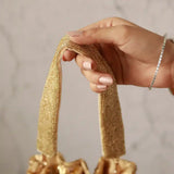 Gold Twinkle Heavy Tassles Potli bag with handle by The Tan Clan, featuring intricate tassel details and a shiny finish.