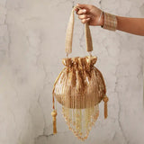Gold Twinkle Heavy Tassles Potli bag with handle by The Tan Clan, featuring intricate tassel details and traditional design.