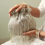 Silver Twinkle Heavy Tassles Potli bag with handle by The Tan Clan, featuring intricate tassel detailing and a compact design.