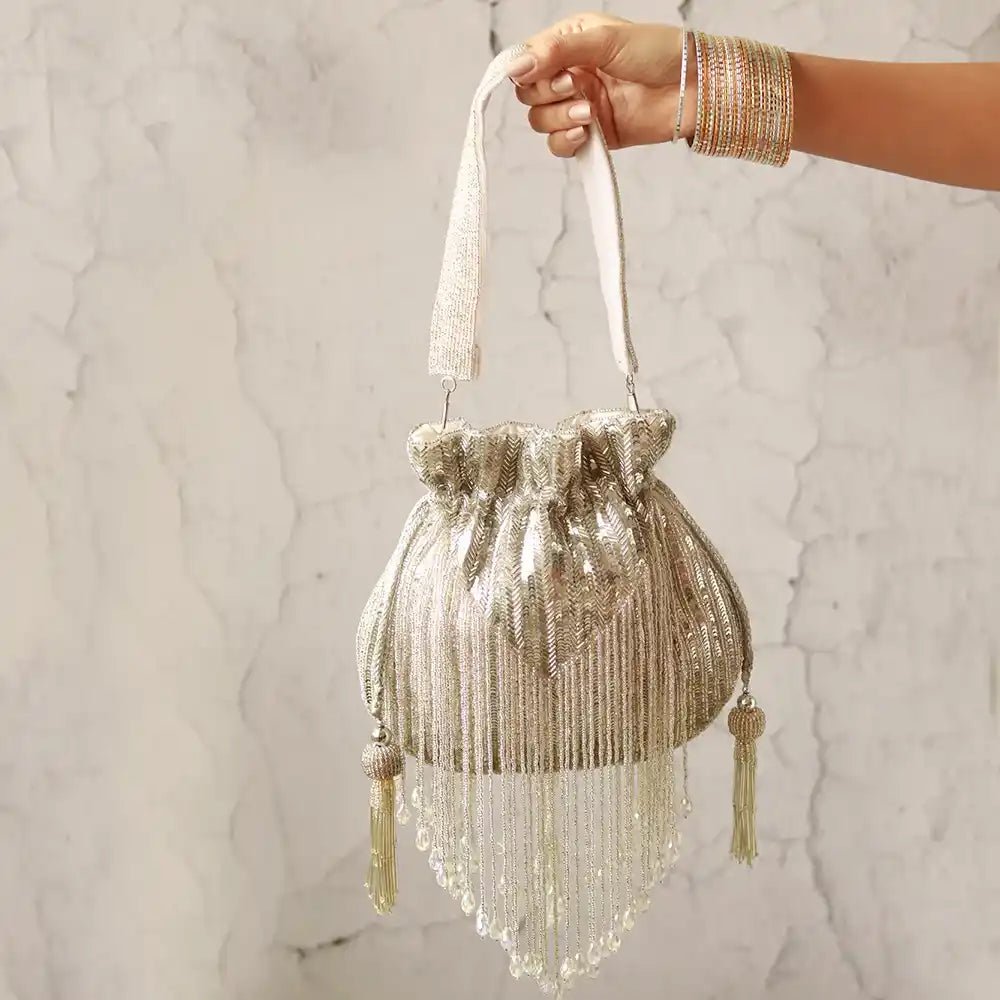Silver THE TAN CLAN Twinkle Heavy Tassles Potli bag with handle, featuring intricate tassel detailing and elegant design.