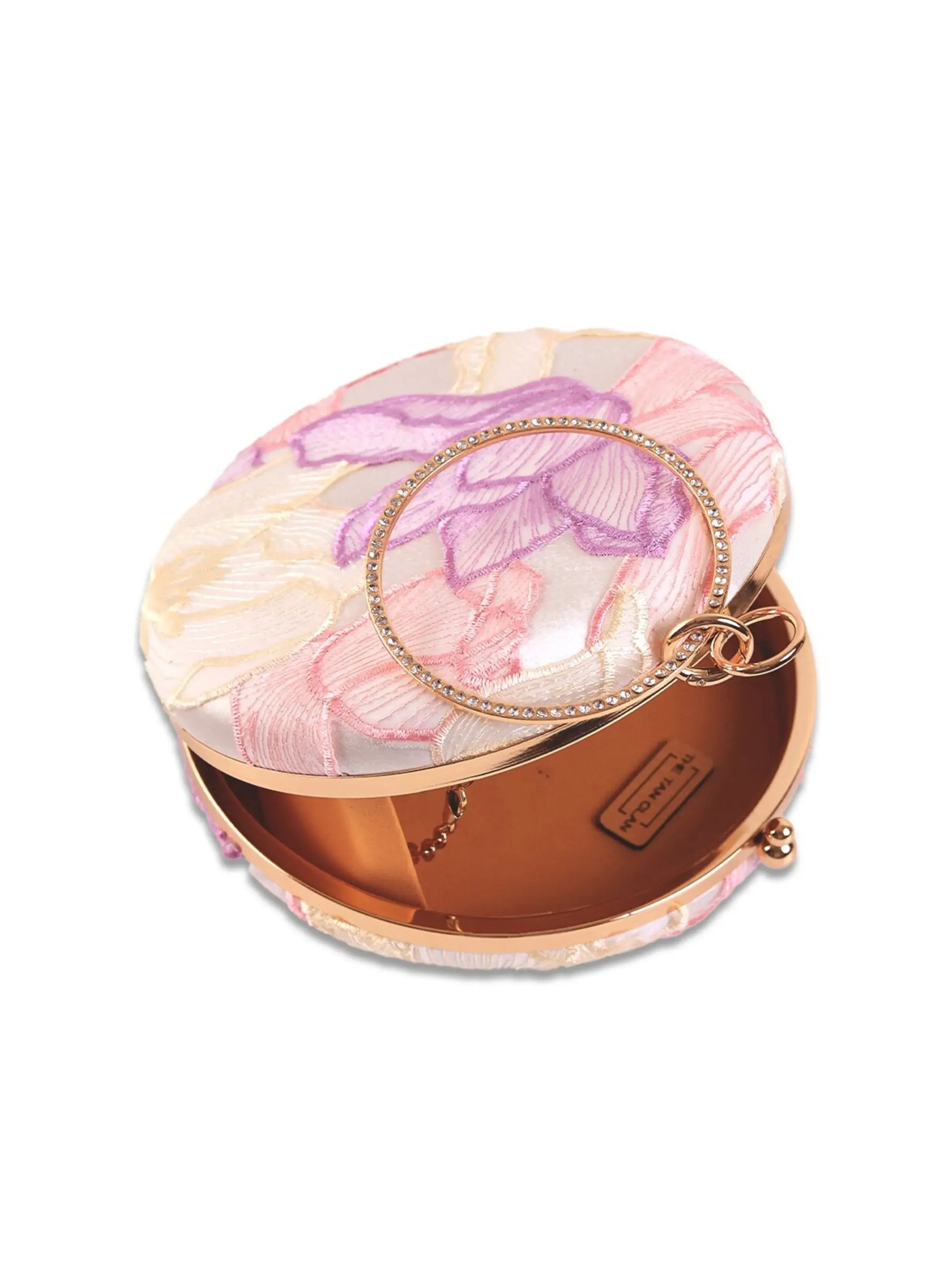 Pink round clutch purse by The Tan Clan featuring a smooth surface and compact design, perfect for accessories and evening outings.