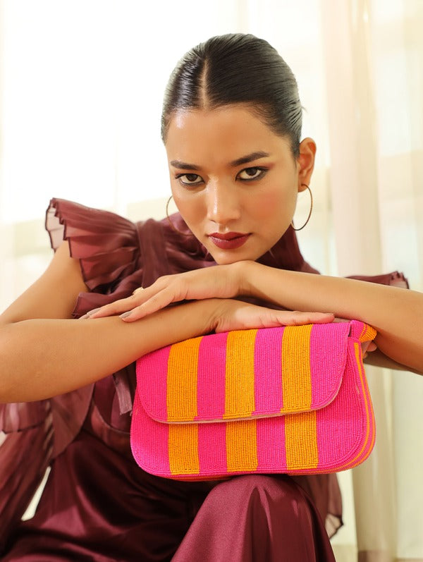Orange and pink tulip-shaped baguette bag with handle by The Tan Clan, featuring a vibrant floral design and compact style.