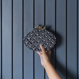 Navy blue hand-embroidered clutch bag by The Tan Clan with intricate embroidery and elegant design.