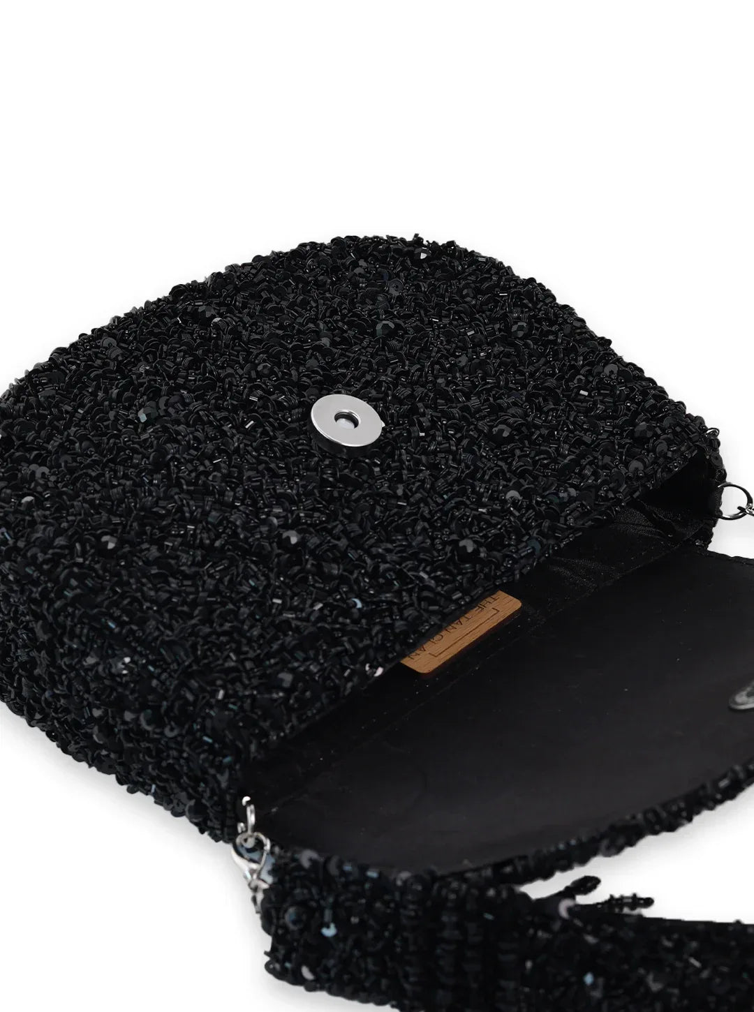 Amy black flap-over bag by The Tan Clan featuring a sleek design with a flap closure and adjustable shoulder strap.