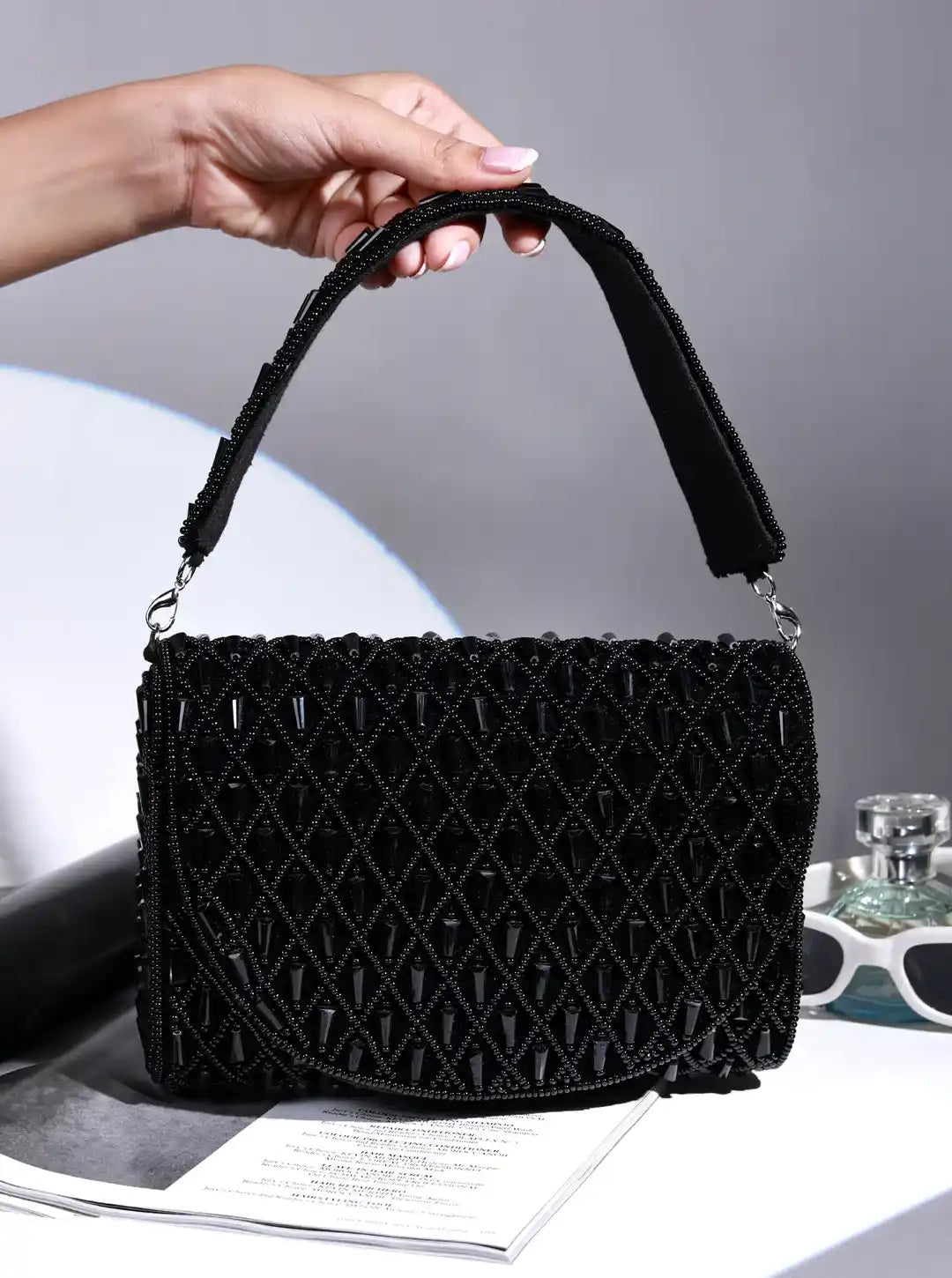 Black Claire flap-over bag by The Tan Clan, stylish flap bag with top handle and spacious interior for everyday use.