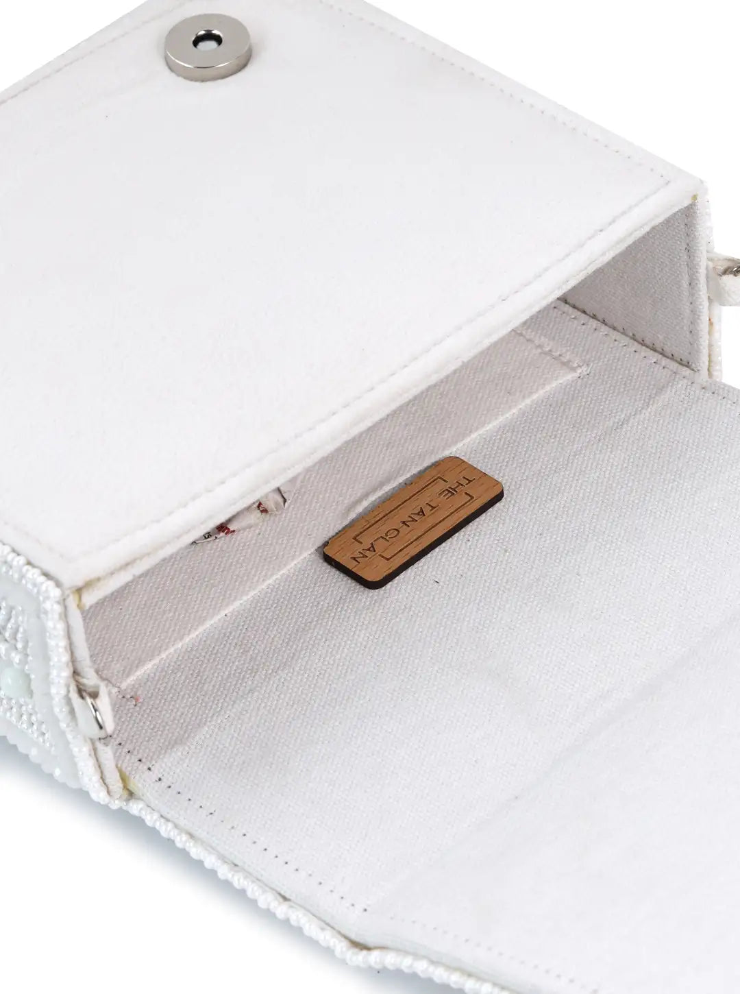 White Megan flap-over bag from The Tan Clan, stylish flap bag with sleek design and top handle for everyday use.