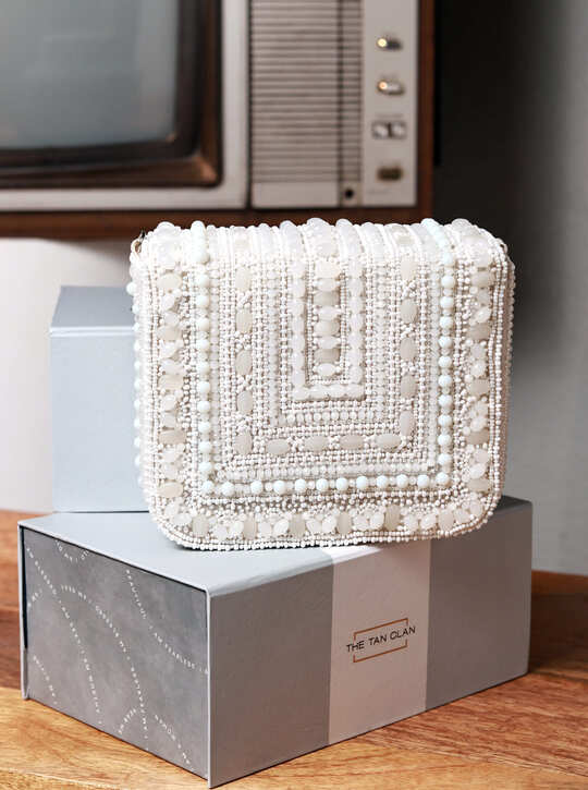White Megan flap-over bag from The Tan Clan featuring a sleek design and a flap closure with a stylish, modern look.