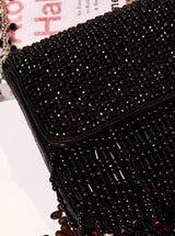 Mira Black Flap Over Bag by The Tan Clan showing a stylish black leather flap bag with a silver clasp and adjustable strap.