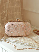 The Tan Clan Inaara Peach Oval Clutch with a sleek design and smooth peach-colored exterior, perfect for elegant occasions.