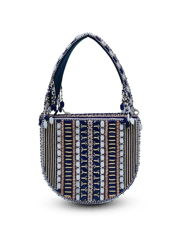 Blue flap-over bag with handle from The Tan Clan featuring a stylish design and spacious interior.