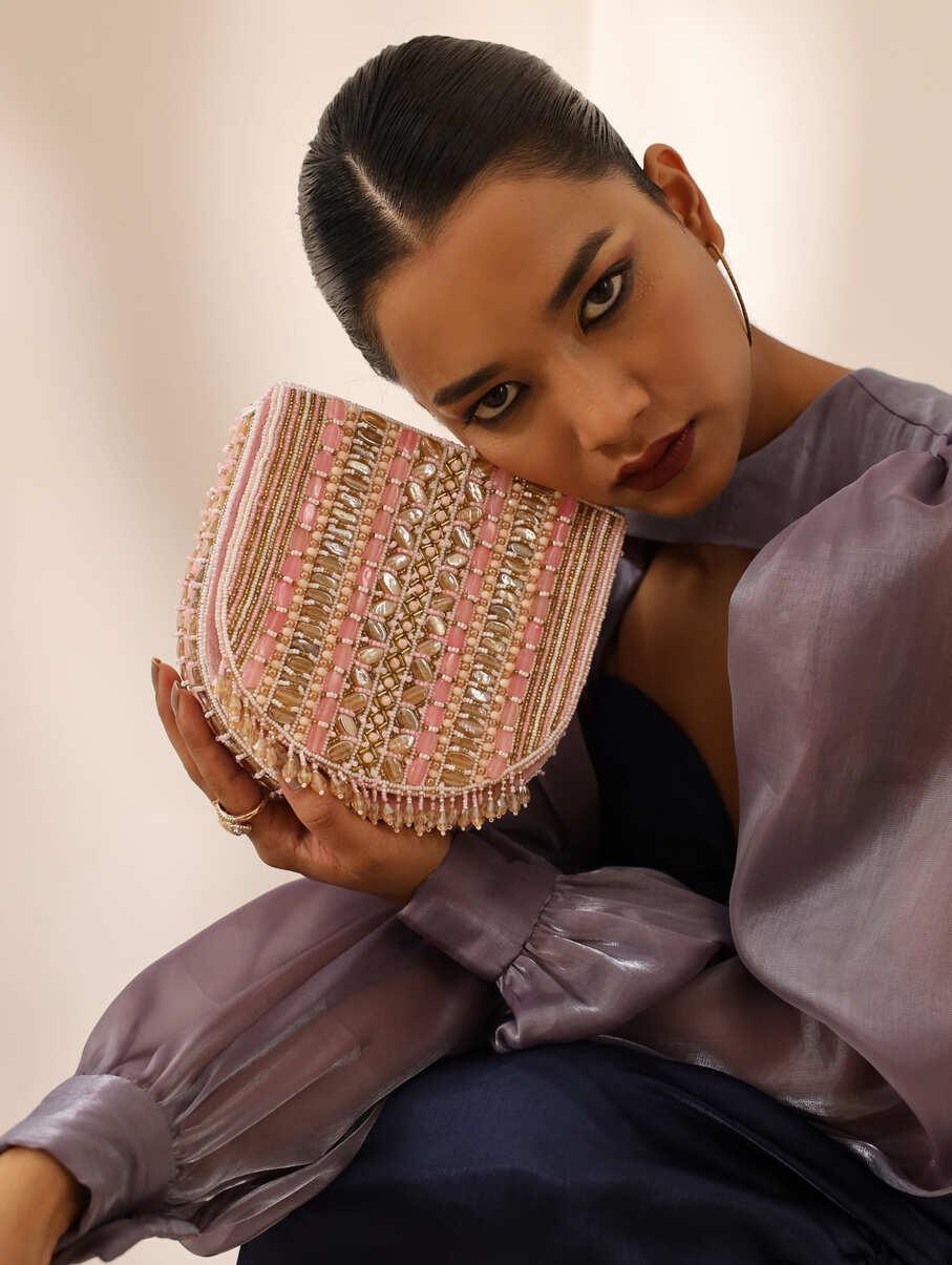 Pink Asma flap-over bag with handle by The Tan Clan, featuring a stylish design and spacious interior.