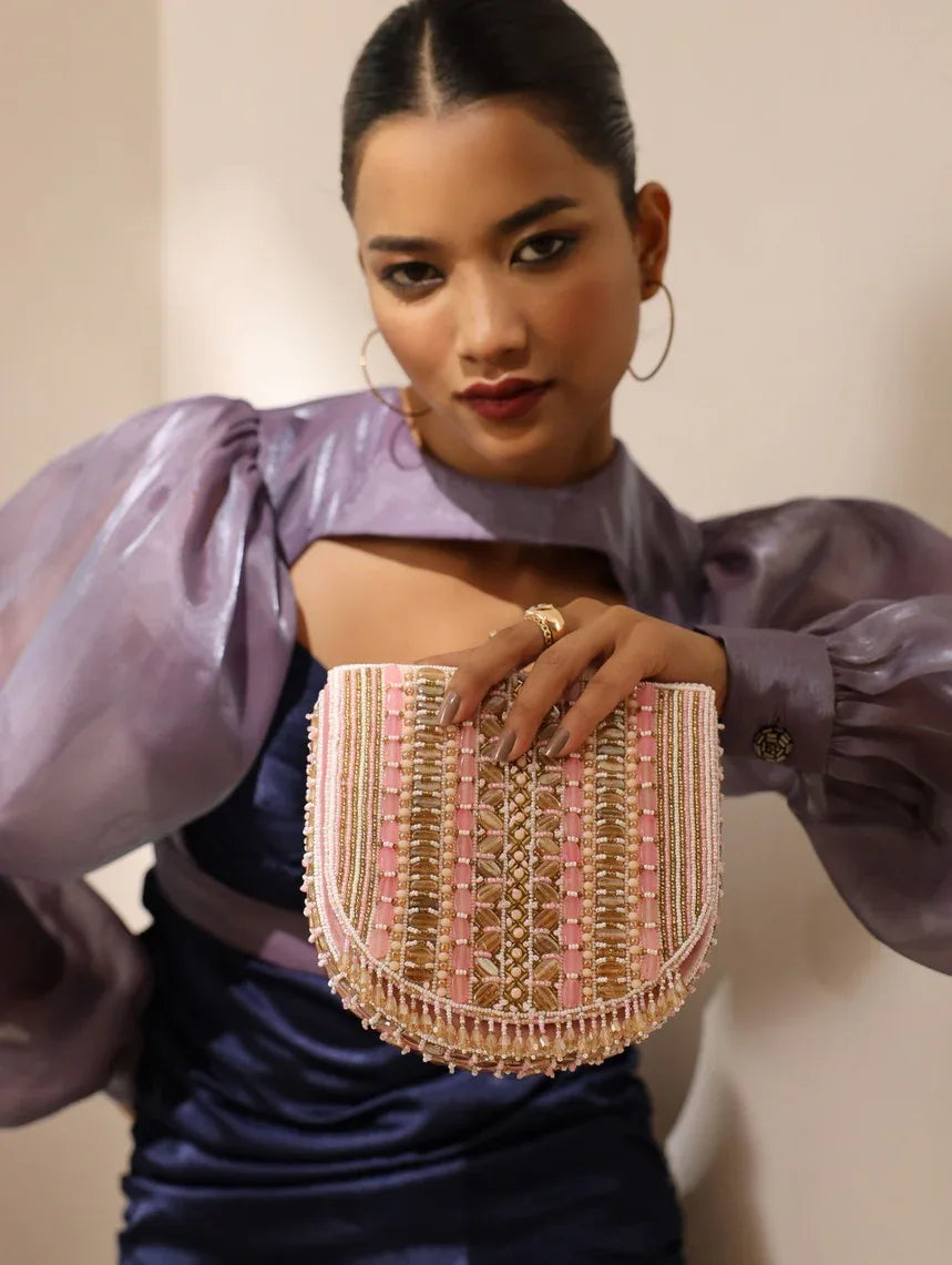 Pink Asma flap-over bag with handle by The Tan Clan, featuring a stylish design and secure closure.