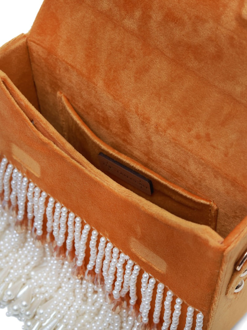 Yellow Kiara flap-over bag with handle by The Tan Clan, showing a stylish design and vibrant color against a plain background.