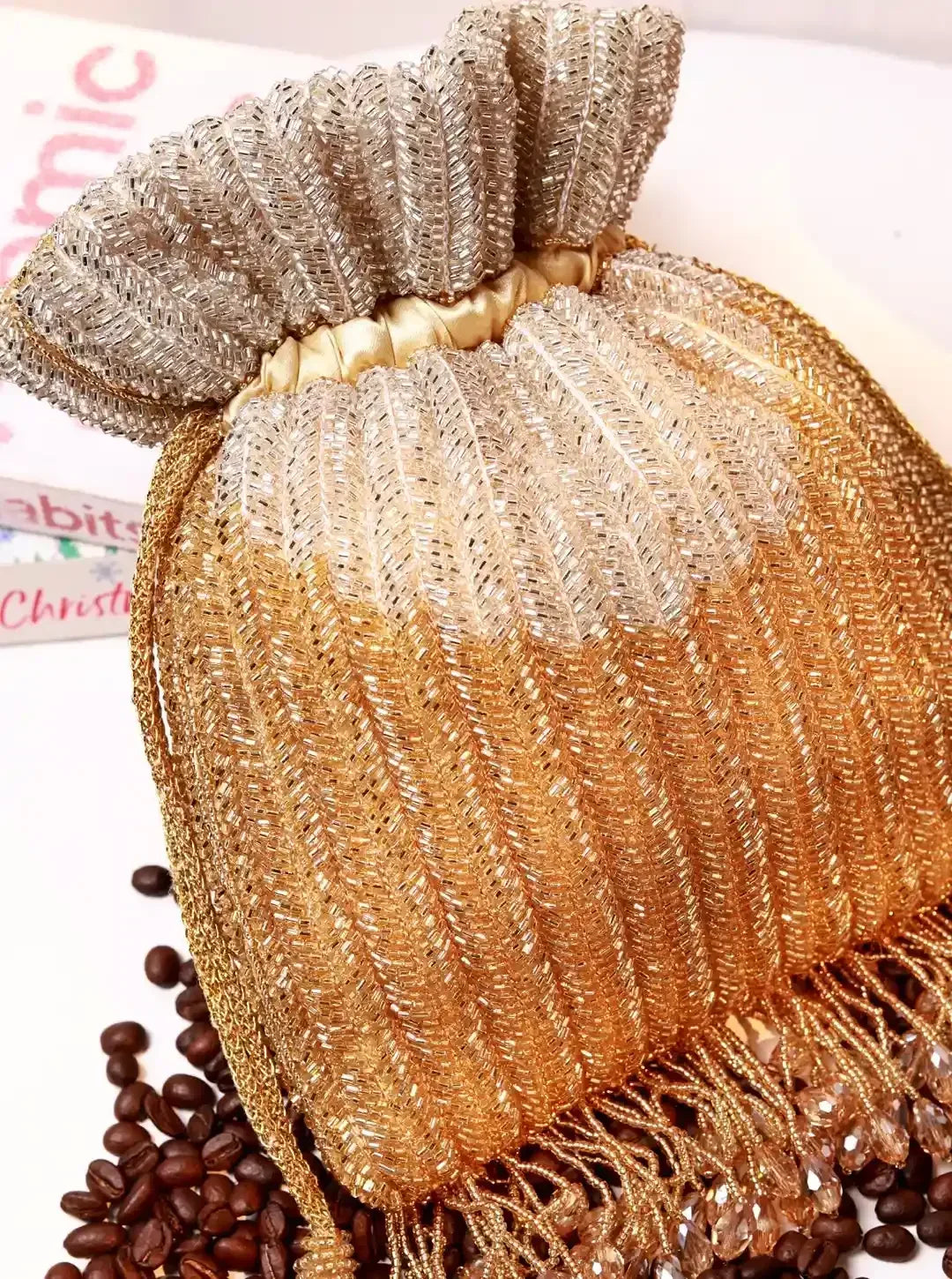 Aarna Gold Potli Bag from The Tan Clan featuring intricate embroidery and a drawstring closure, perfect for traditional occasions.