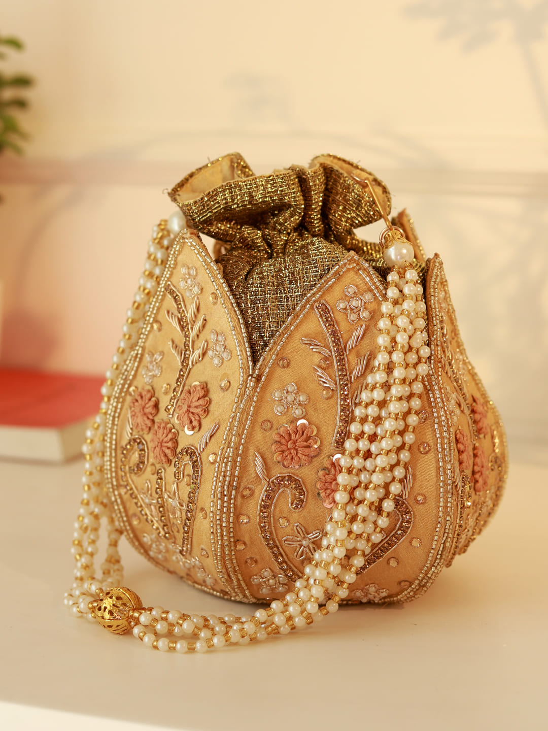 Gold lotus design Baag Potli bag by The Tan Clan with intricate embroidery and traditional Indian style.