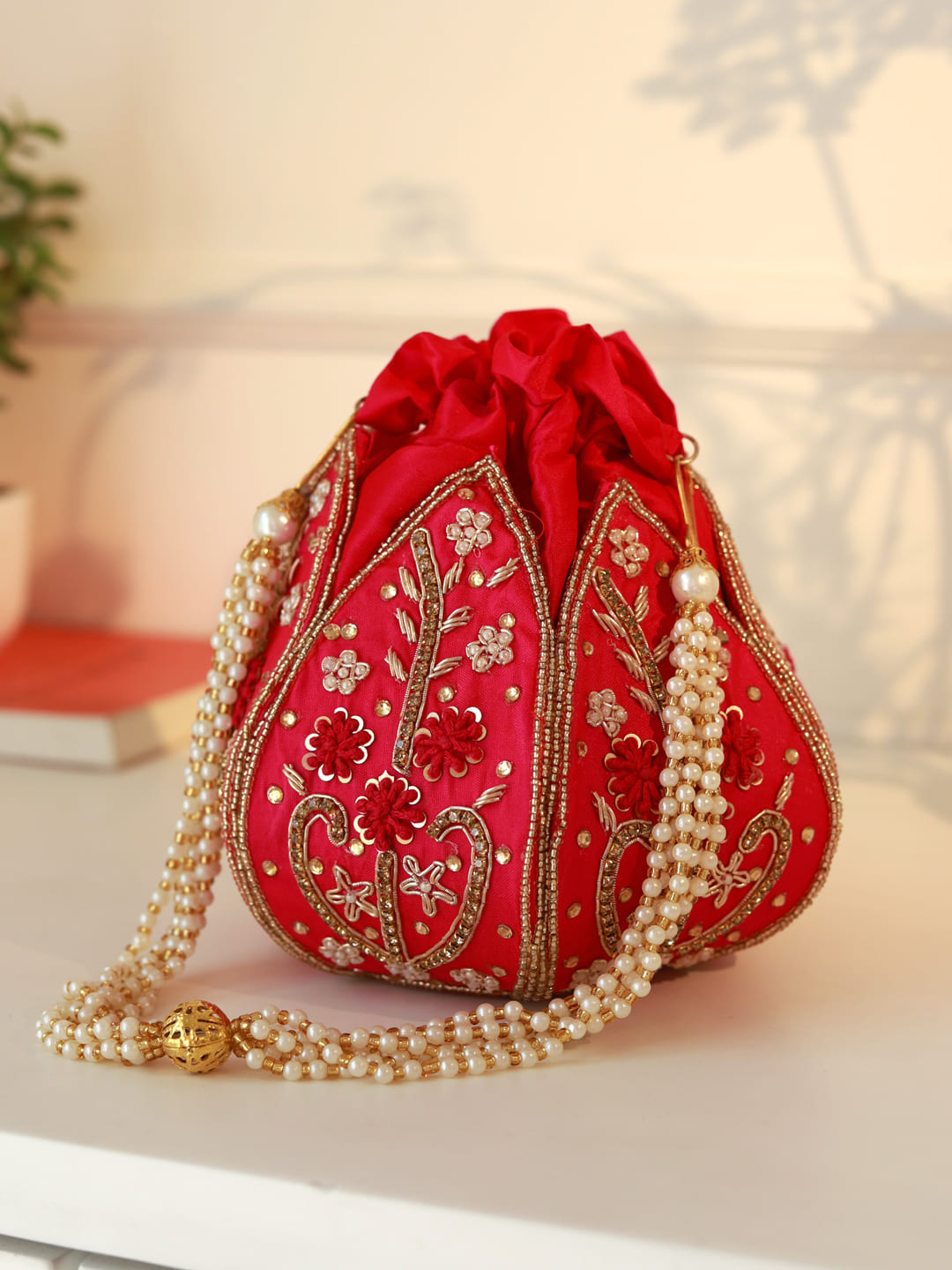 Hot pink Lotus Potli bag by The Tan Clan, stylish traditional Indian potli with intricate design and drawstring closure.