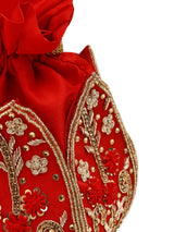 Red lotus-patterned Baag potli bag from The Tan Clan with traditional drawstring closure and decorative tassels.
