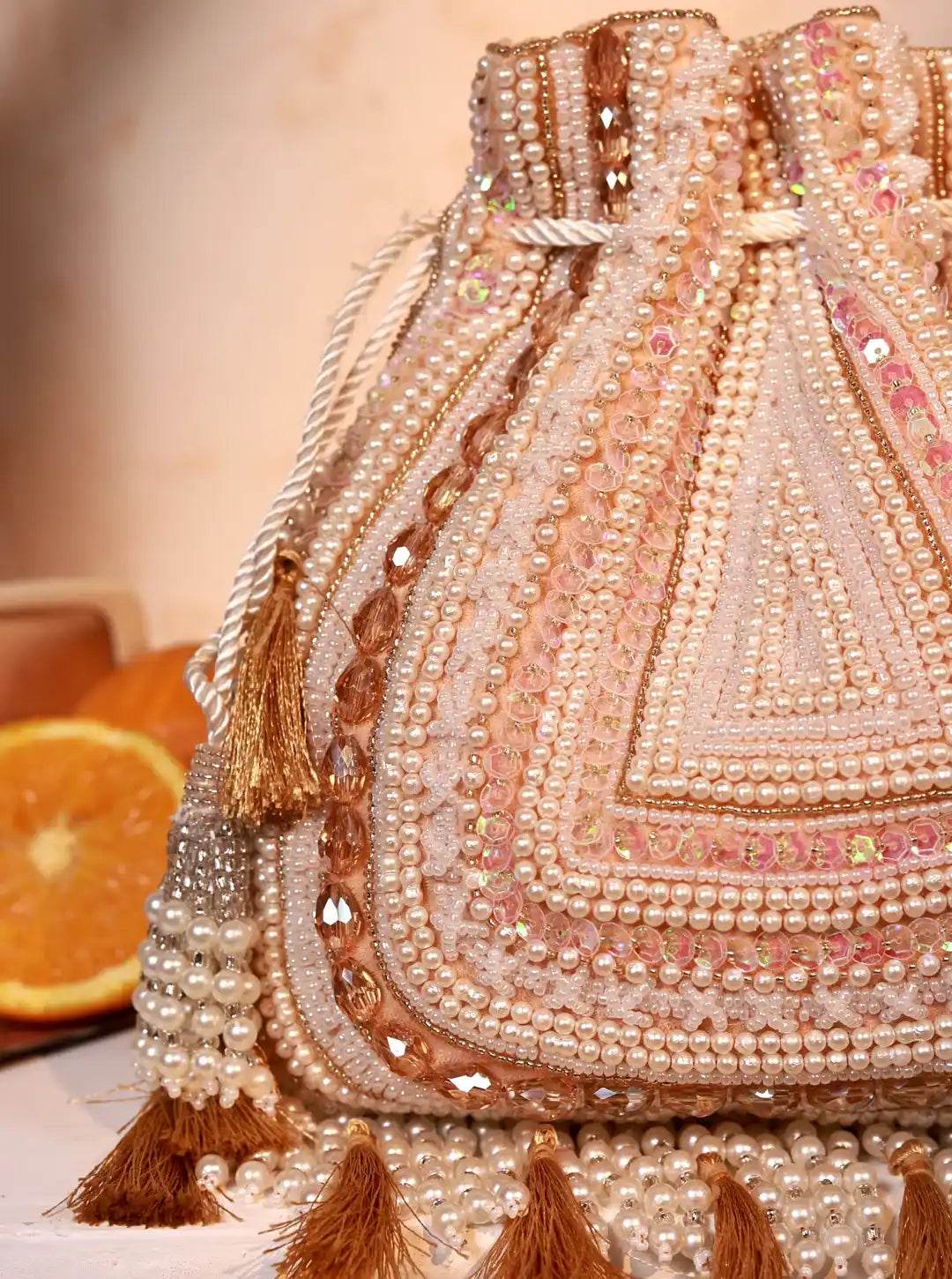 Nora beige tasselled Potli Bag by The Tan Clan with intricate detailing and traditional drawstring closure.